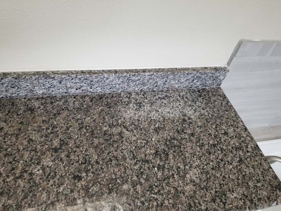 20230123_113338 This shows a bathroom vanity with stains in the granite